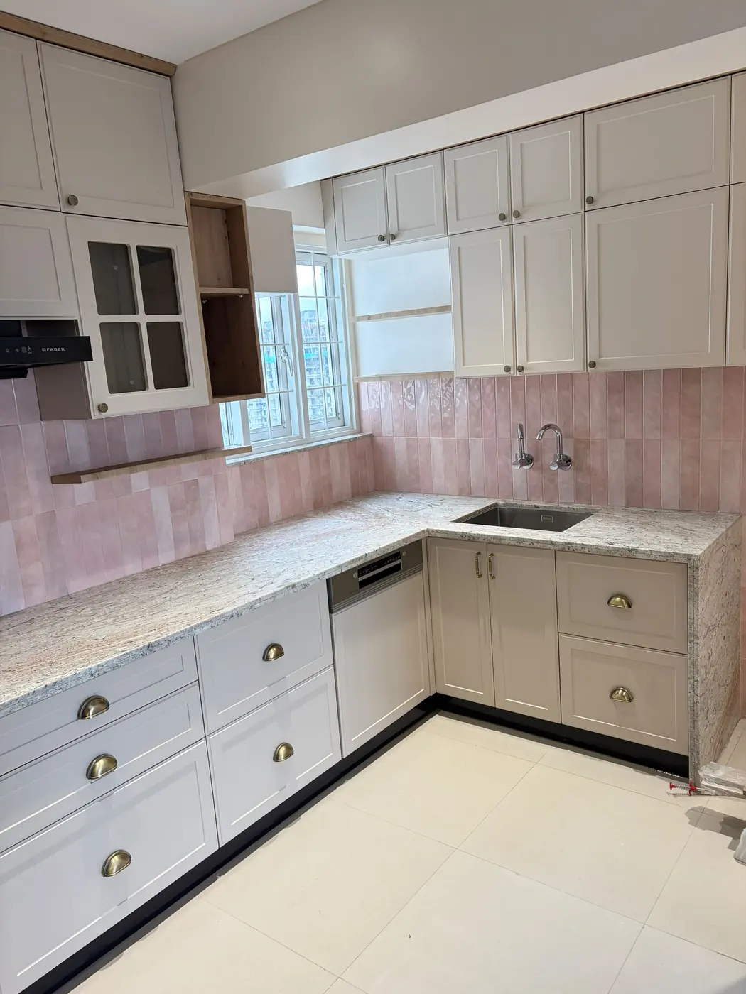 White L-shaped modular kitchen with granite counter and cup-handle drawers, Pune